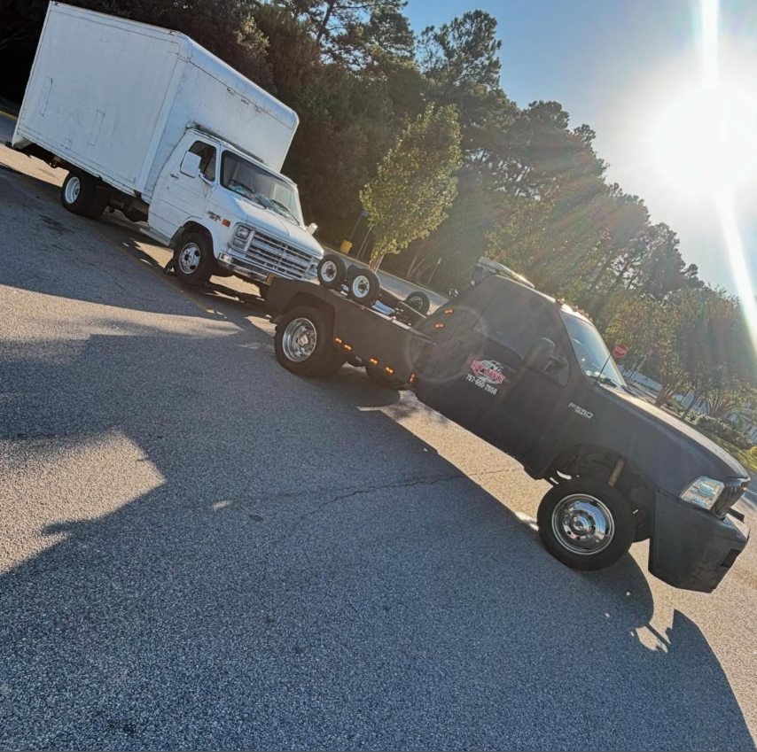 Rioliable Towing hauling a box truck in a parking lot